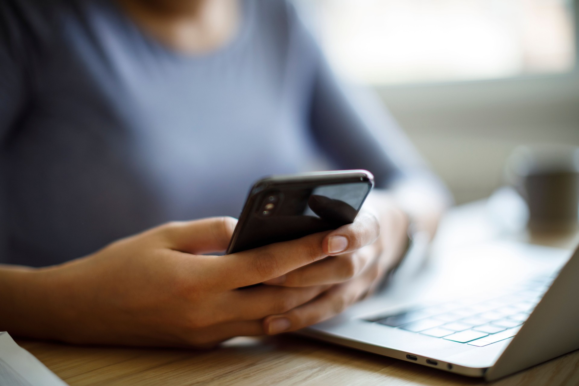 Woman using mobile phone and laptop for working